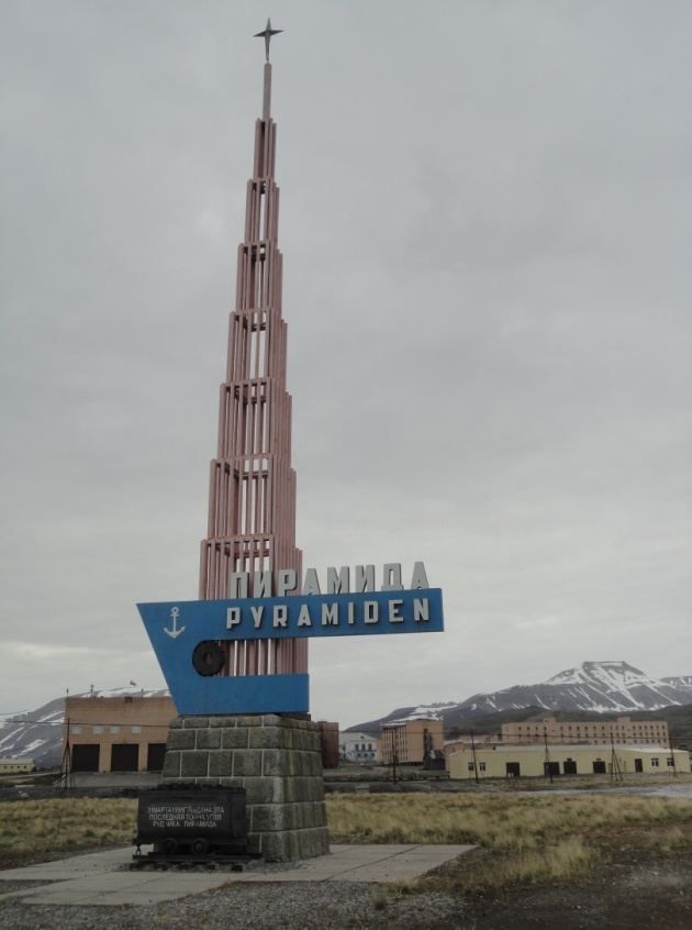 Frente al monumento que marca la entrada en el asentamiento de Pyramiden se encuentra el último carbón extraído de la mina antes de su cierre a finales de los 90. Foto: Alba Aguión.